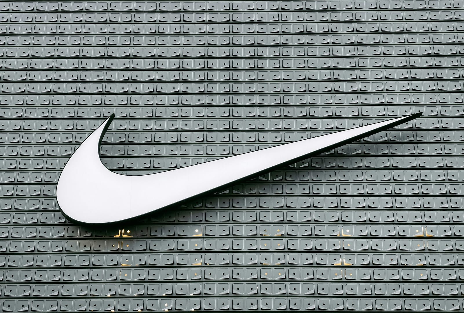 Top 5 Sports Marketing Campaigns Ever The Nike swoosh logo on a patterned wall, symbolising one of the most iconic sports marketing brands in the world.
