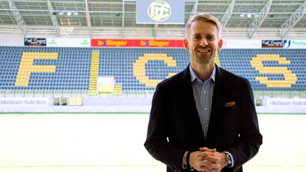Jan Wappler Jan Wappler standing in front of the FC Schaffhausen stadium stands, smiling in a suit