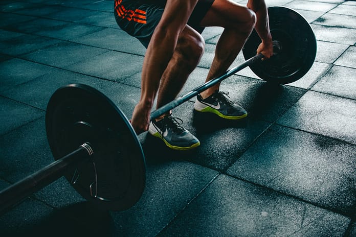 Athlete preparing to lift a barbell in a gym, symbolising strength, discipline, and training focus.