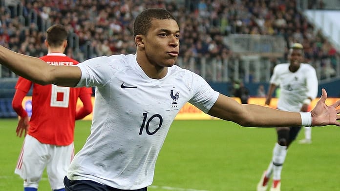 France forward celebrating a goal with arms outstretched during an international football match in March 2018.