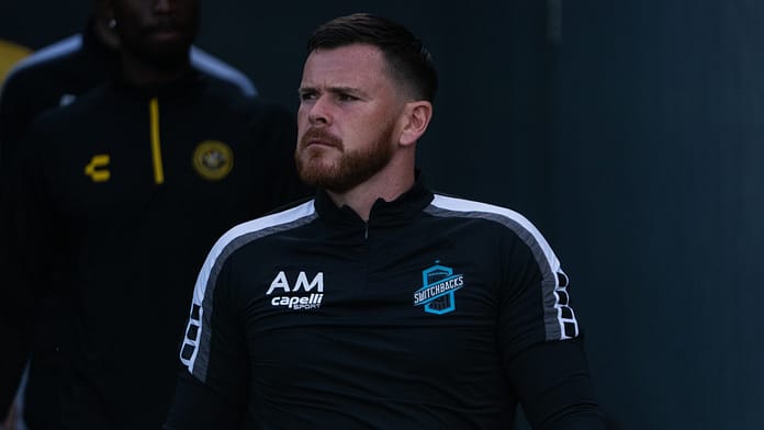 Alan McCann walks out of the tunnel in Switchbacks training gear, focused and composed before a match.